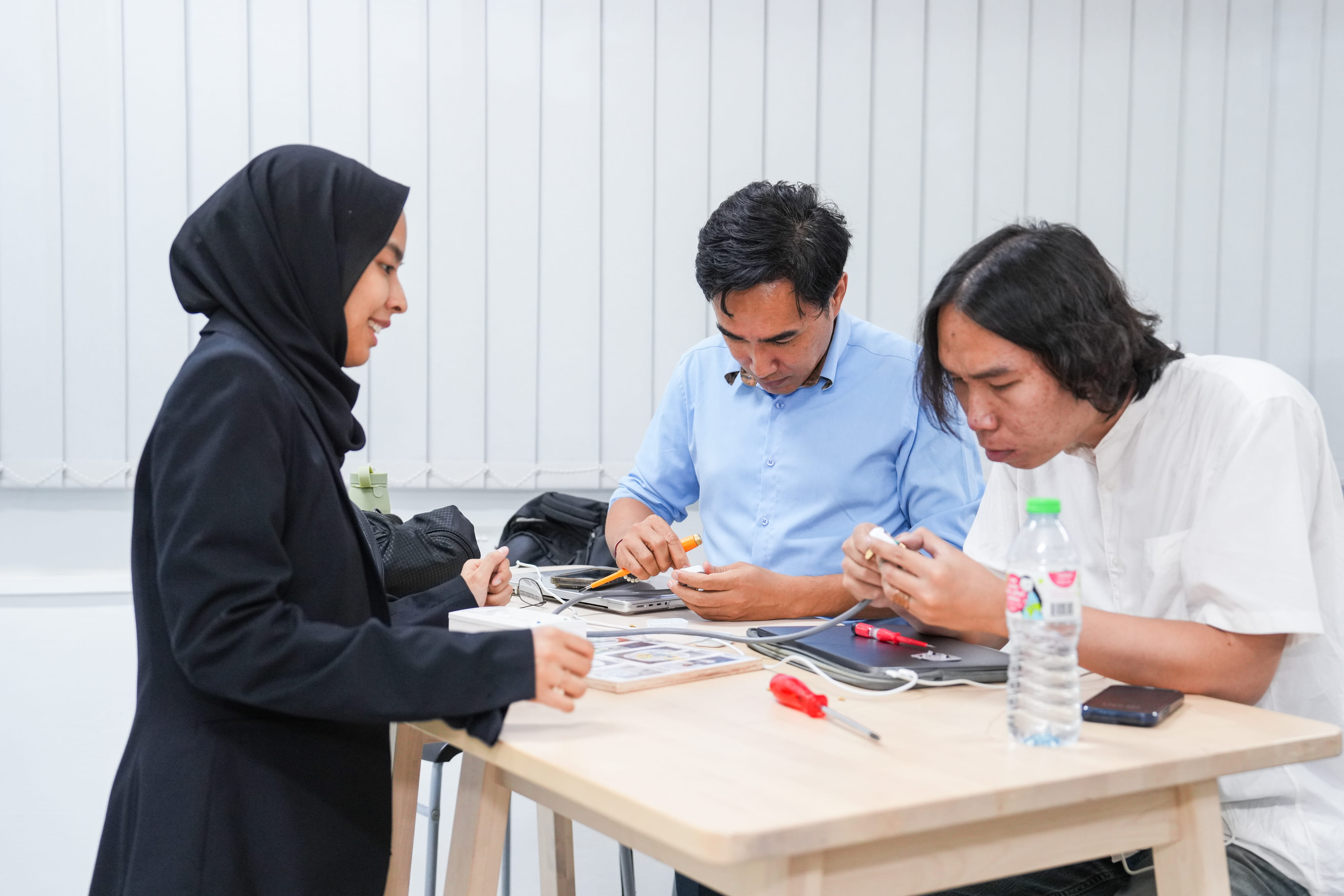 Journalists learning to repair a three-pin plug at Repair Kopitiam